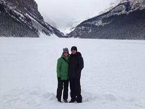 Couple Standing On A Frozen Lake Louise